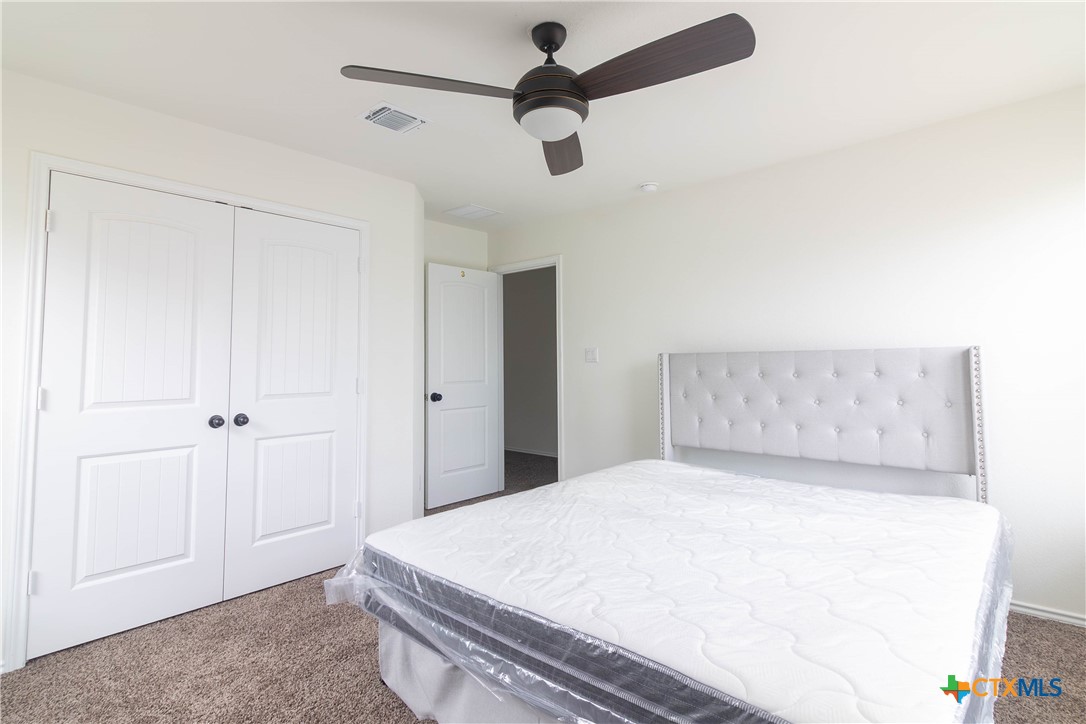 1131 Aronia Lane Georgetown, TX 78626 - Photo 27 of 36 a bedroom with a bed and a chandelier