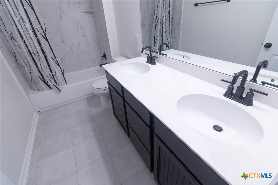 1131 Aronia Lane Georgetown, TX 78626 - Photo 32 of 36 a bathroom with a double vanity sink and a mirror
