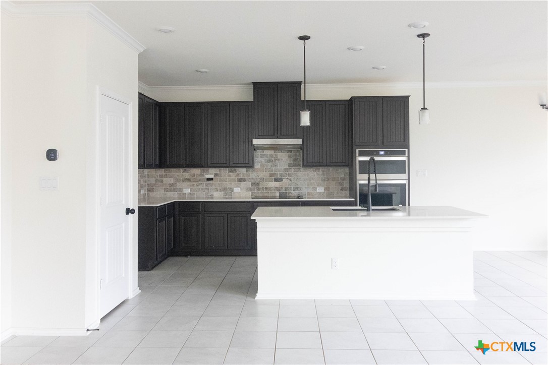 1131 Aronia Lane Georgetown, TX 78626 - Photo 5 of 36 a kitchen with kitchen island granite countertop a sink a counter top space and stainless steel appliances