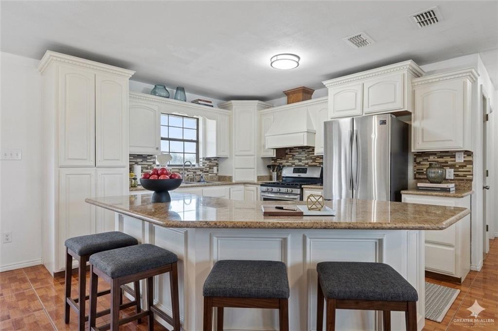 24175 Engleman Road Edcouch, TX 78538 - Photo 12 of 22 a kitchen with stainless steel appliances a dining table chairs refrigerator and sink