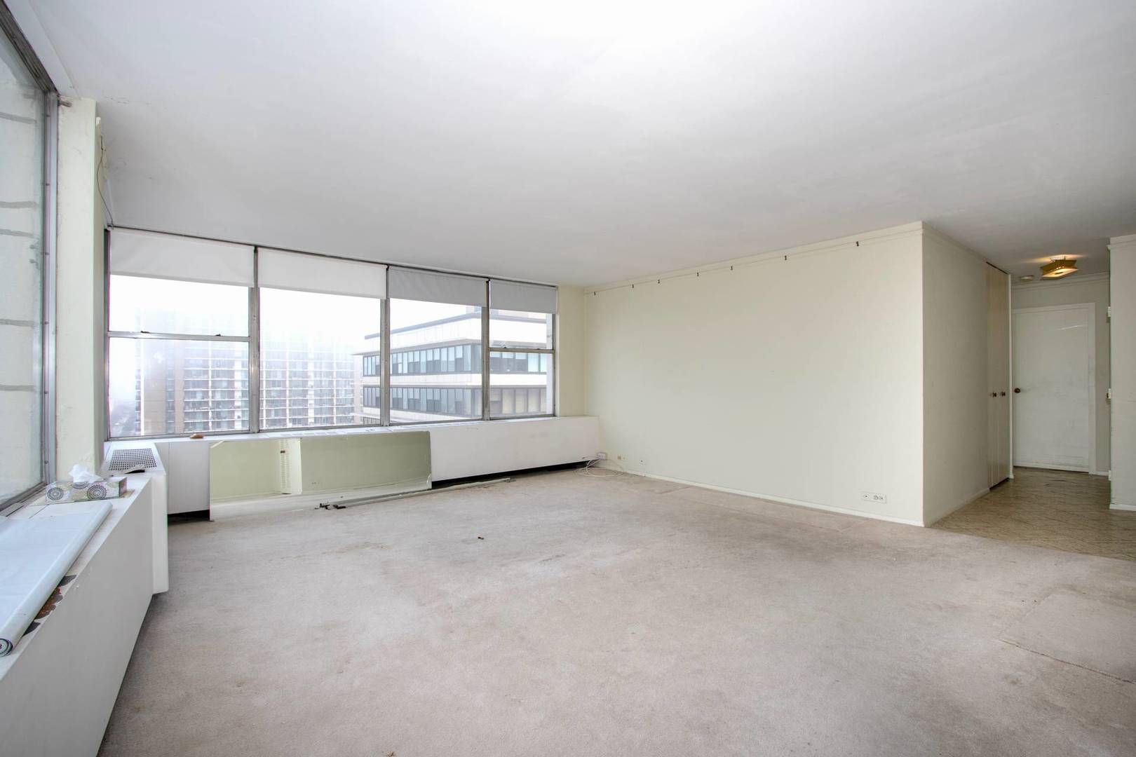 5757 North Sheridan Road, Unit 18J Chicago, IL 60660 - Photo 2 of 16 an empty room with large windows