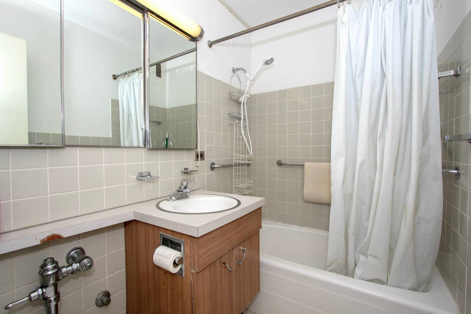 5757 North Sheridan Road, Unit 18J Chicago, IL 60660 - Photo 13 of 16 a bathroom with a sink and a mirror with bathtub