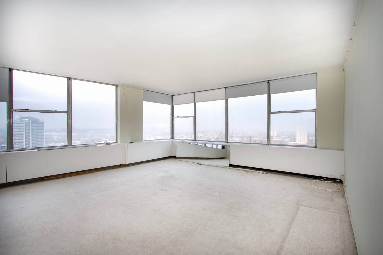 5757 North Sheridan Road, Unit 18J Chicago, IL 60660 - Photo 3 of 16 an empty room with large windows and city view