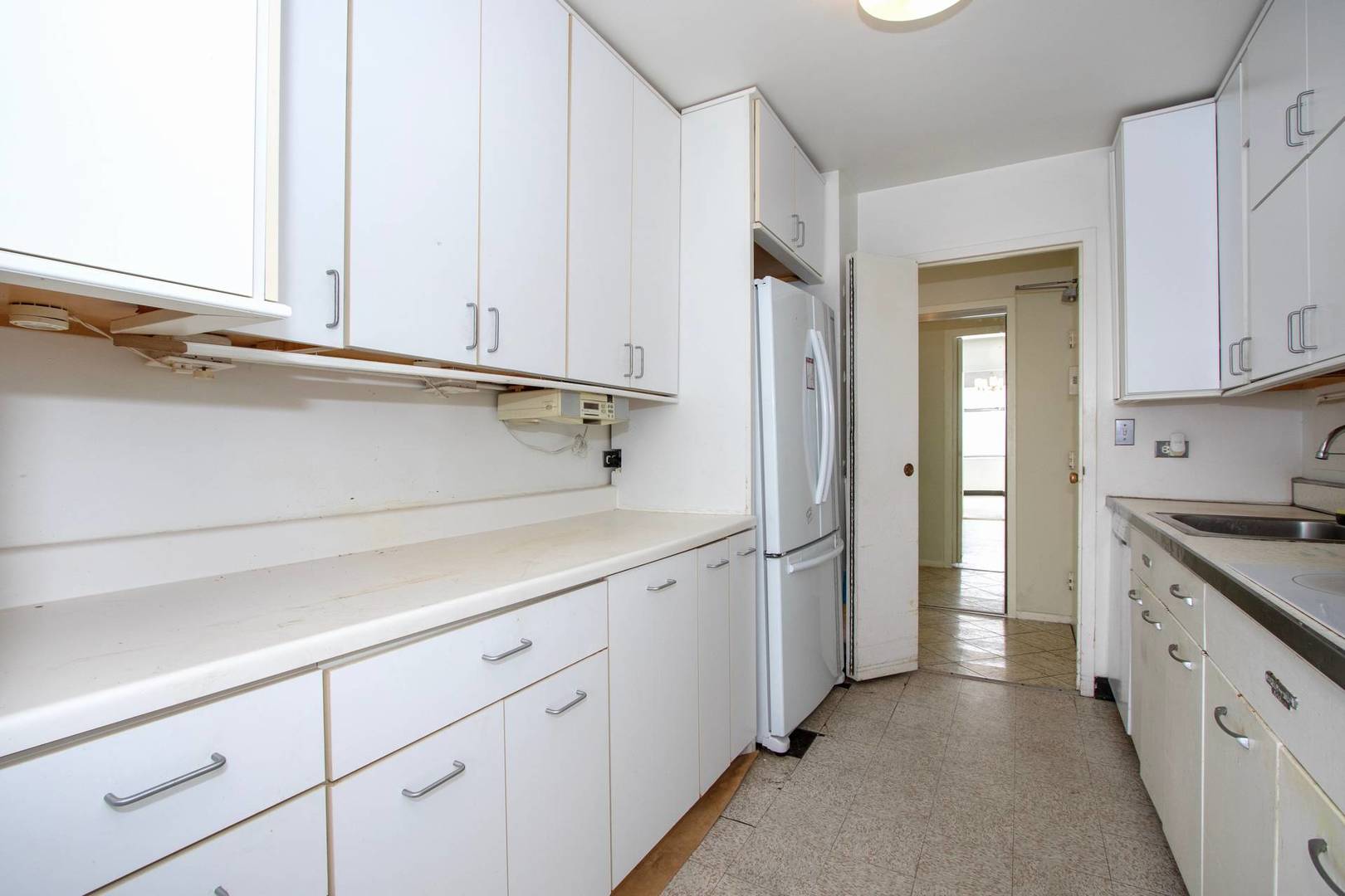 5757 North Sheridan Road, Unit 18J Chicago, IL 60660 - Photo 6 of 16 a view of a kitchen with white cabinets