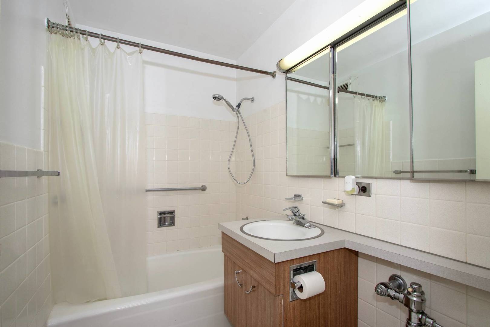 5757 North Sheridan Road, Unit 18J Chicago, IL 60660 - Photo 9 of 16 a bathroom with a granite countertop sink a mirror and a shower