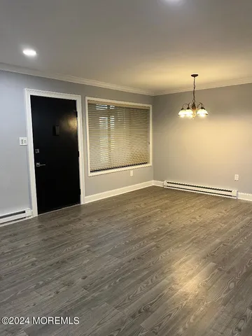 an empty room with wooden floor and cabinet