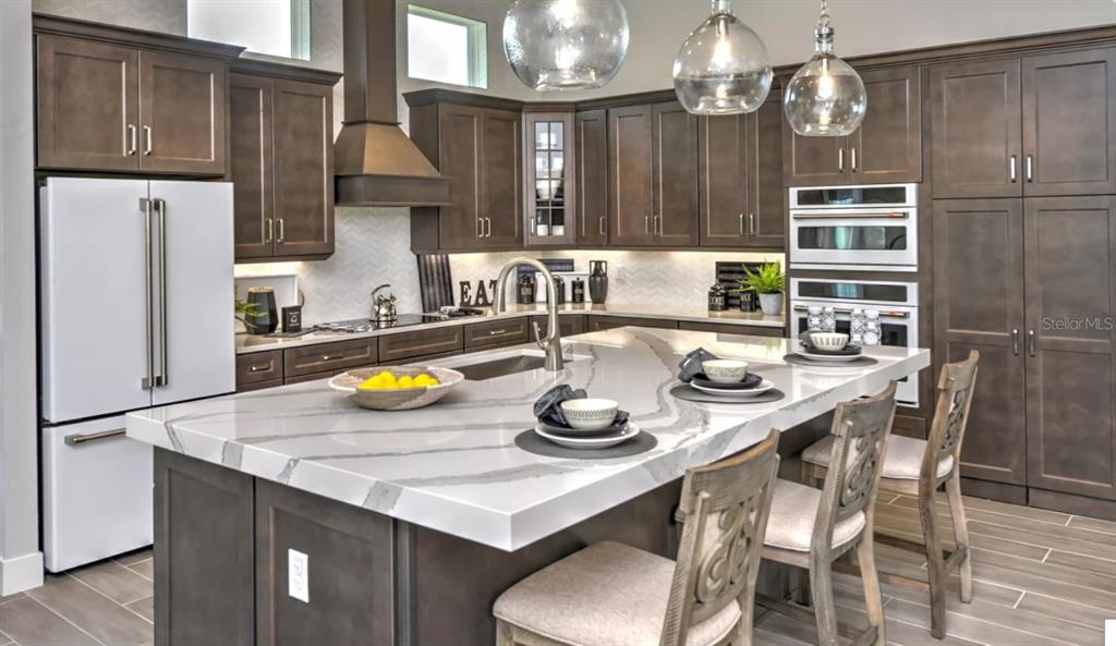 177 Aspen Way Palm Coast, FL 32137 - Photo 3 of 11 a kitchen with a sink a stove and chairs