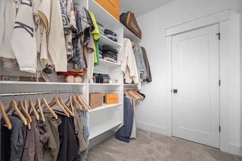 a view of walk in closet with clothes and shoes
