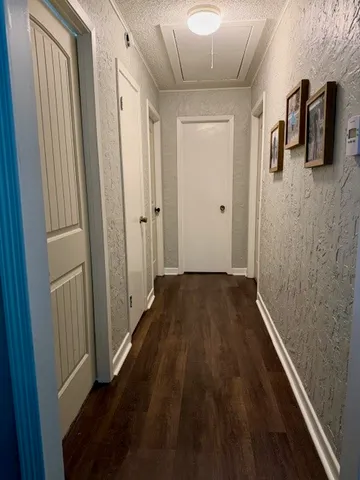 a view of a hallway with wooden floor