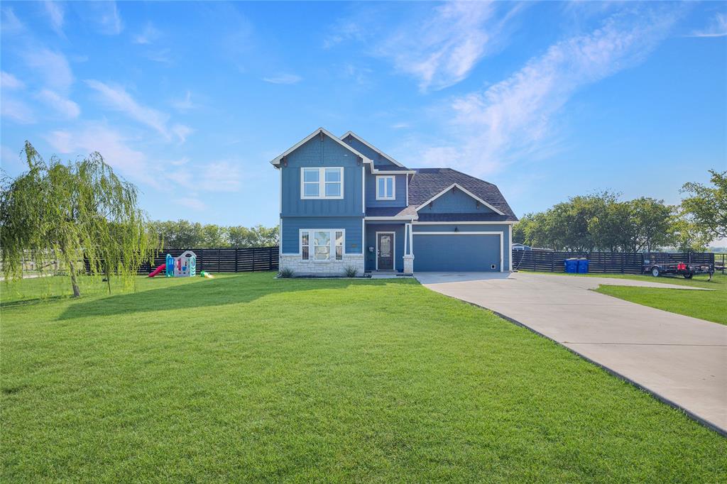 a front view of a house with a yard and trees