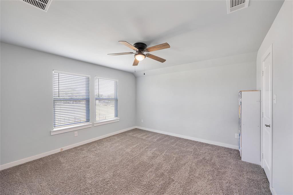 12616 Metz Road Sanger, TX 76266 - Photo 17 of 26 an empty room with chandelier fan and windows