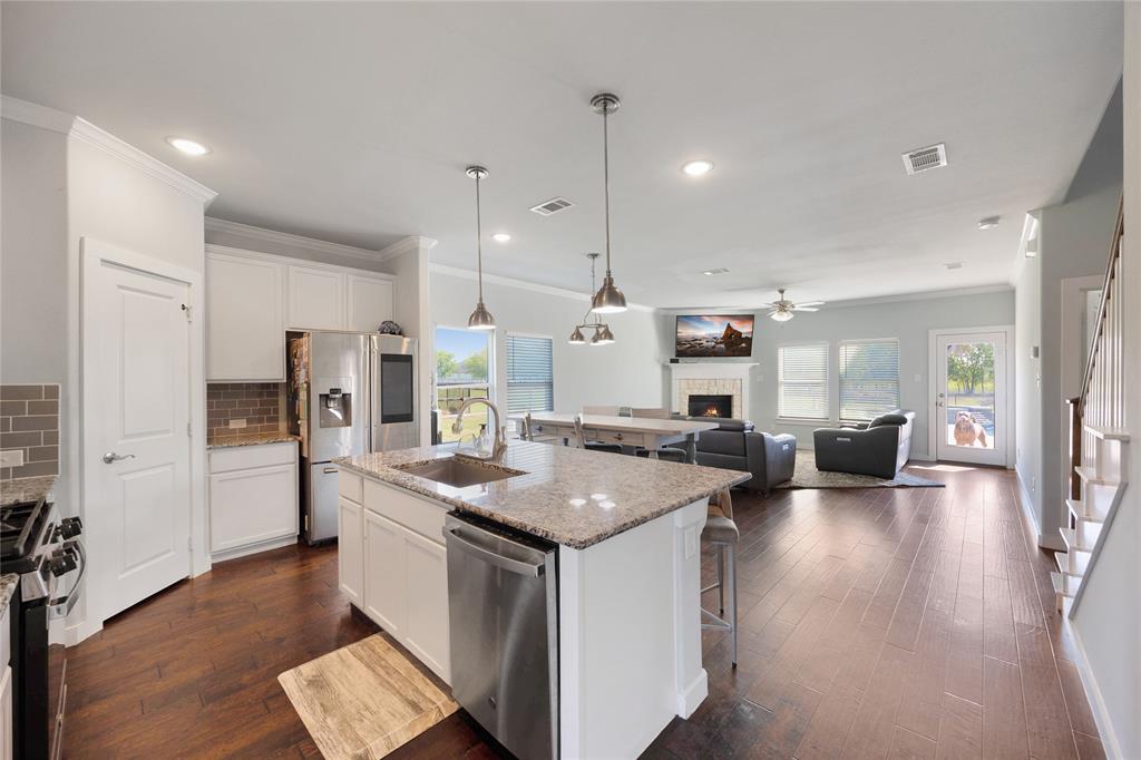 12616 Metz Road Sanger, TX 76266 - Photo 26 of 26 a kitchen with a stove a refrigerator a sink dishwasher with a dining table and chairs with wooden floor