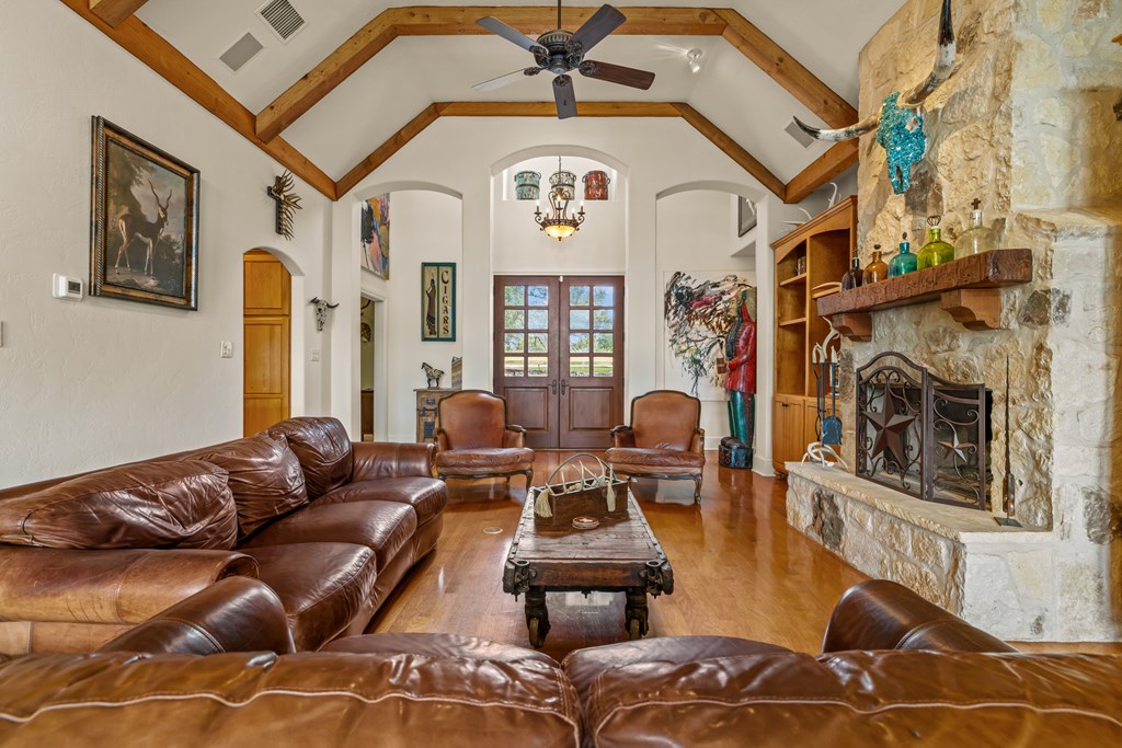 1320 Pass Creek Road East Center Point, TX 78010 - Photo 5 of 51 a living room with furniture a fireplace and a floor to ceiling window