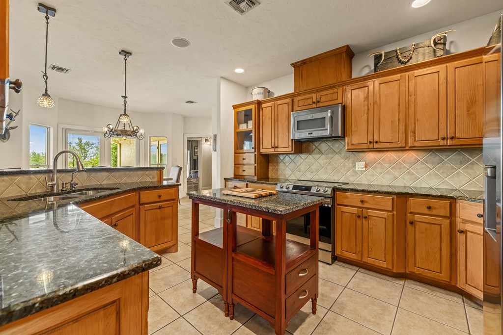 1320 Pass Creek Road East Center Point, TX 78010 - Photo 7 of 51 a kitchen with stainless steel appliances granite countertop a sink a stove and a wooden cabinets