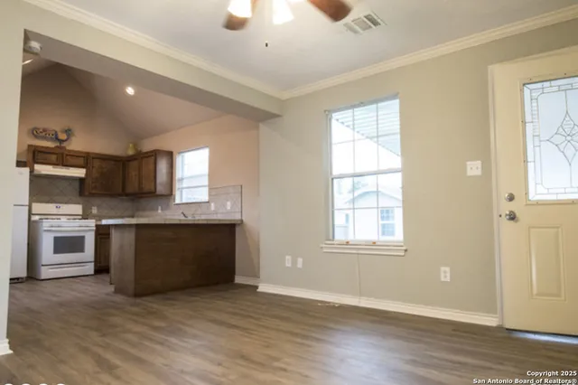 a view of kitchen with granite countertop stainless steel appliances and window