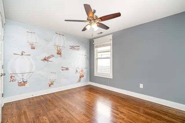 a view of a livingroom with wooden floor and a ceiling fan