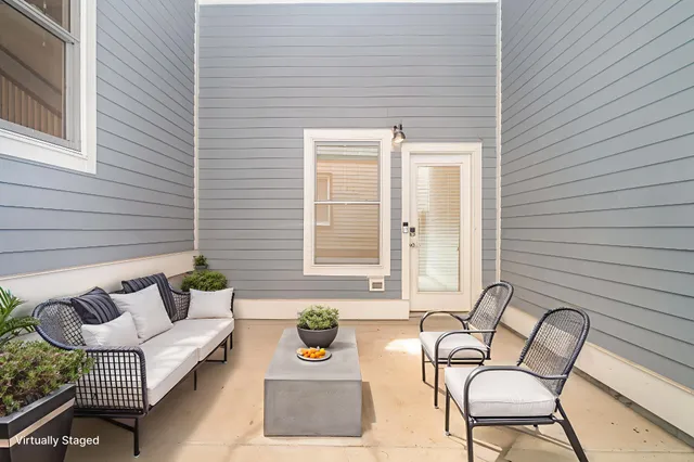 a balcony with couches and a potted plant