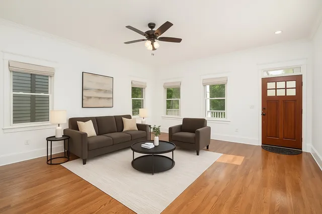 a living room with furniture and a wooden floor