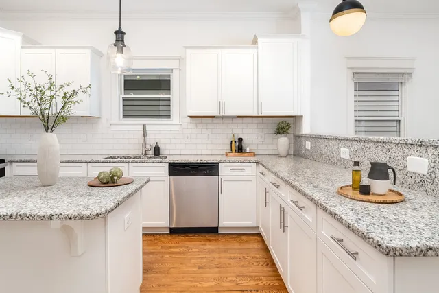 a kitchen with granite countertop a sink a stove and cabinets