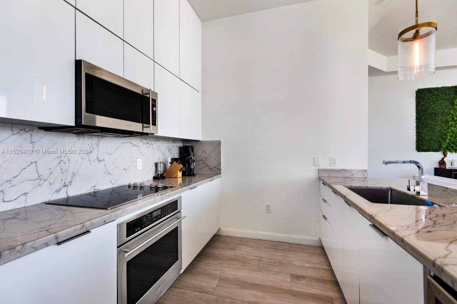 45 Southwest 9th Street, Unit PH4801 Miami, FL 33130 - Photo 16 of 41 a kitchen with stainless steel appliances granite countertop a sink and a microwave