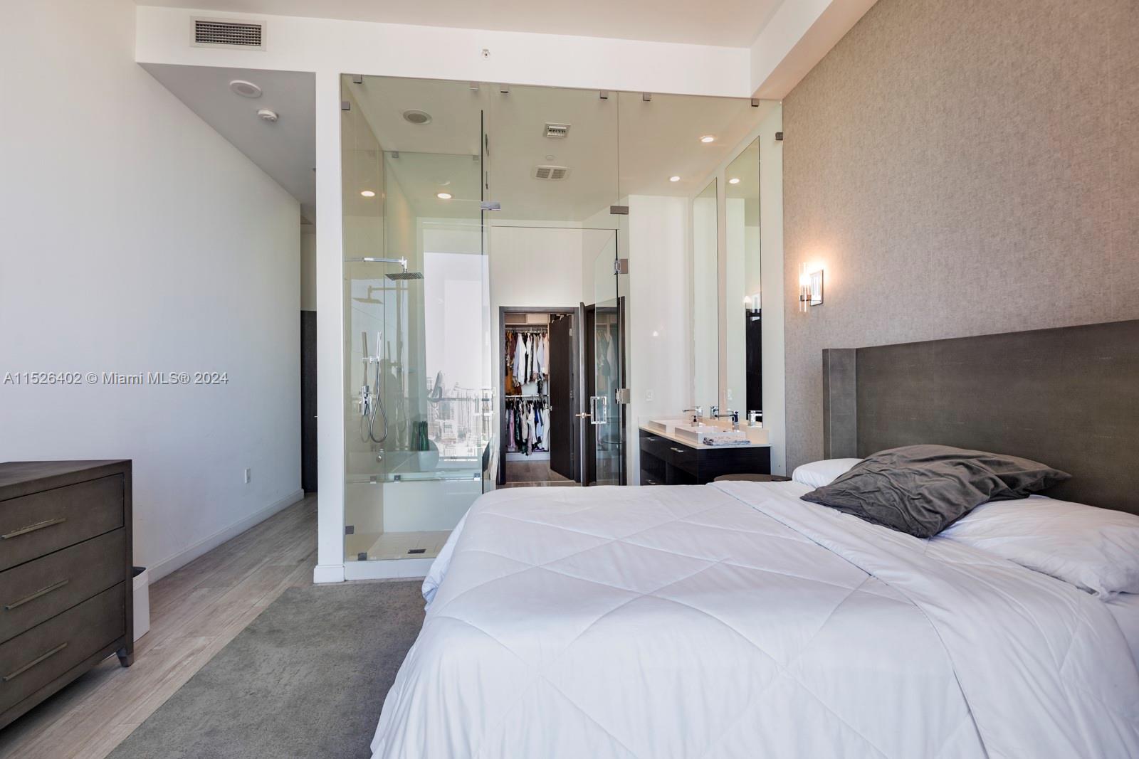 45 Southwest 9th Street, Unit PH4801 Miami, FL 33130 - Photo 18 of 41 a large bedroom with a bed and a large mirror