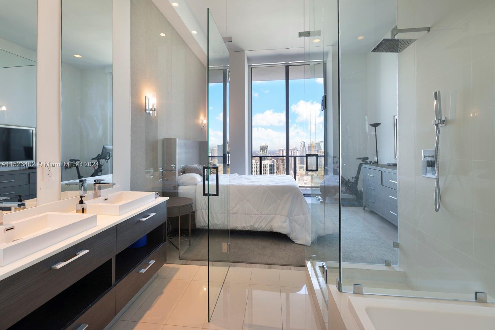 45 Southwest 9th Street, Unit PH4801 Miami, FL 33130 - Photo 20 of 41 a large bathroom with a double vanity sink large mirror and shower