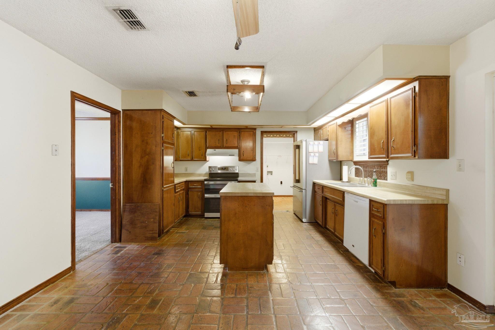 934 Springmier Place Pensacola, FL 32514 - Photo 7 of 49 a large kitchen with a stove a refrigerator a sink dishwasher with a dining table and chairs