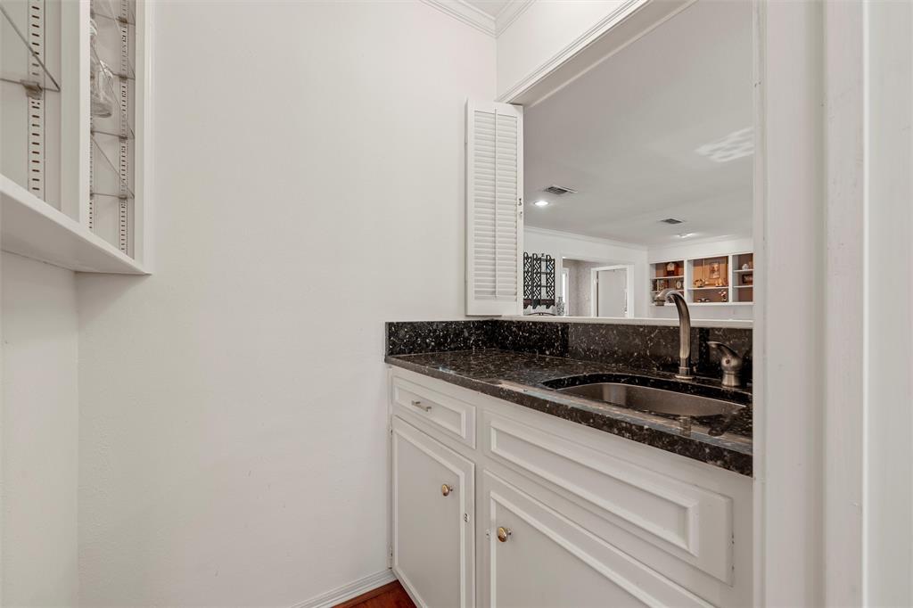 3907 Old Mill Road Waco, TX 76710 - Photo 7 of 30 Bar area featuring white cabinets, ornamental molding, and dark stone countertops