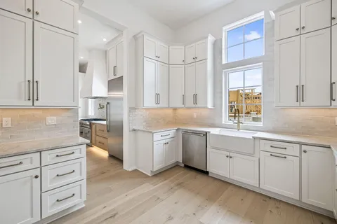 an empty room with wooden floor ceiling fan and windows
