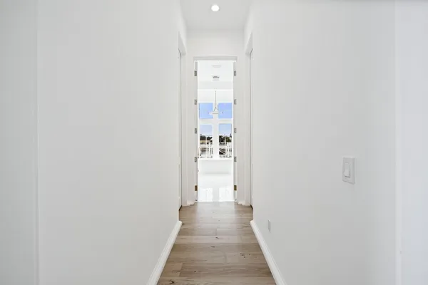 a view of a hallway with wooden floor