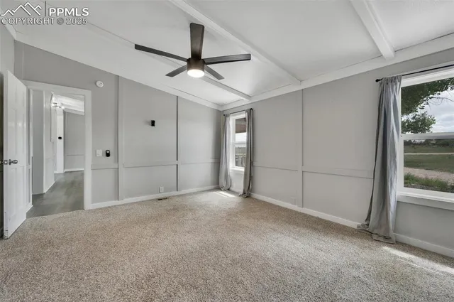 an empty room with fan and entryway