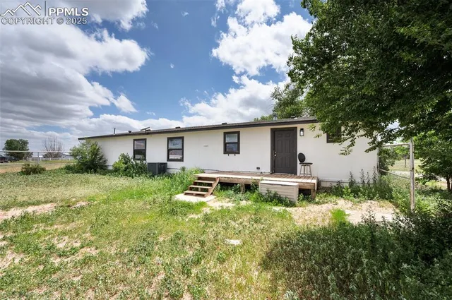 a view of backyard of house with green space