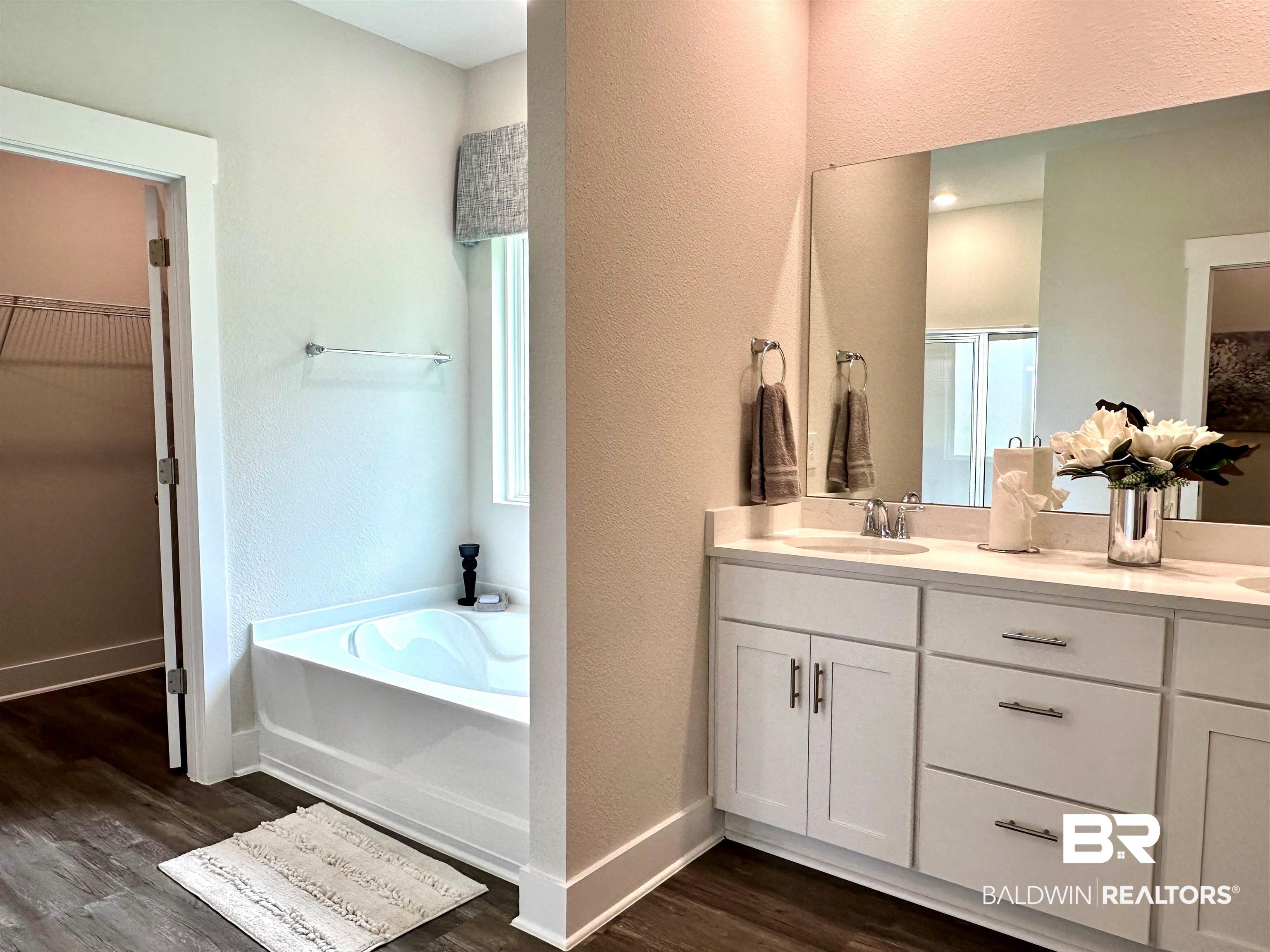 370 Barndling Street Fairhope, AL 36532 - Photo 19 of 30 Bathroom with dual vanity, a bathing tub, and hardwood / wood-style flooring