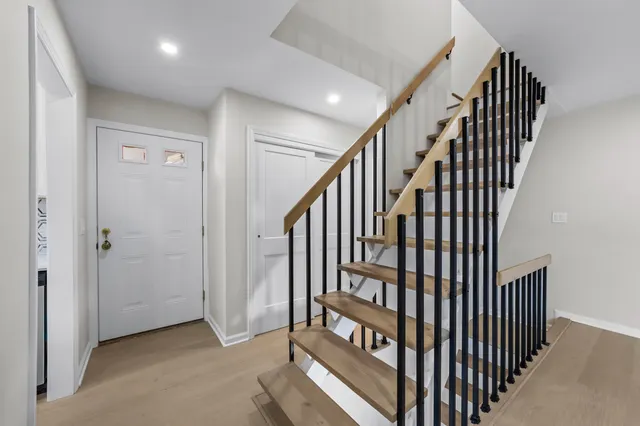 a view of a hallway with wooden floor and staircase