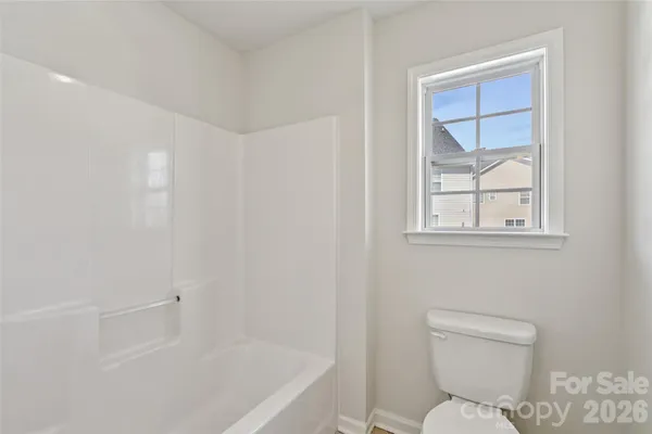 a white toilet sitting next to a bath tub