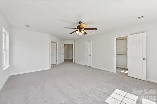a view of an empty room with a ceiling fan
