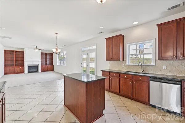 a large kitchen with stainless steel appliances granite countertop a sink and a stove