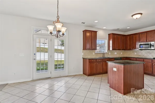 a kitchen with stainless steel appliances granite countertop a stove a sink dishwasher and a refrigerator