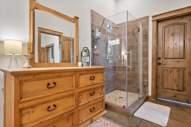 a bedroom with bed and a lamp on dresser