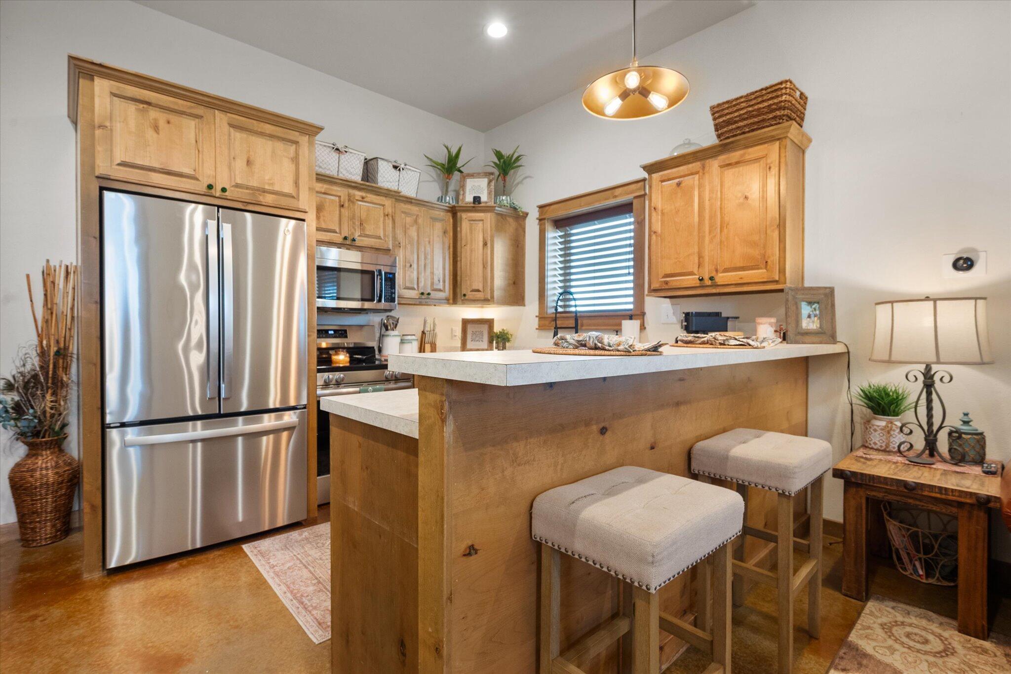 753 Co Road Plainview, TX 79072 - Photo 8 of 39 a kitchen with stainless steel appliances granite countertop a refrigerator a sink dishwasher a dining table and chairs with wooden floor