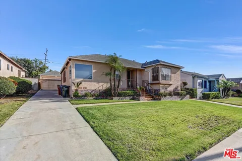 a view of a big house with a big yard and large trees