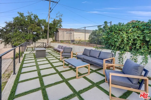a view of a patio with couches table and chairs and potted plants