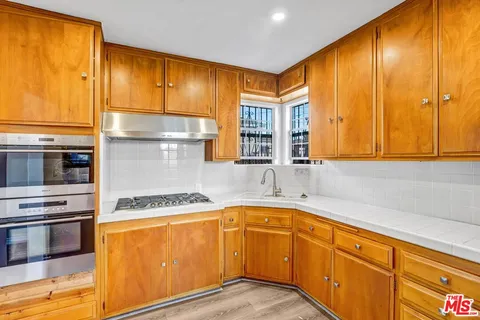 a kitchen with stainless steel appliances granite countertop a sink and cabinets