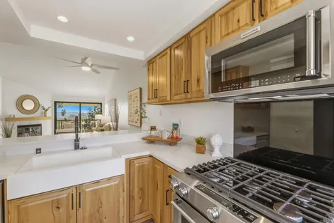 a kitchen with stainless steel appliances a stove a sink cabinets and a window