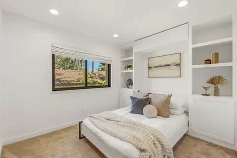 a bedroom with a bed and painting on the wall