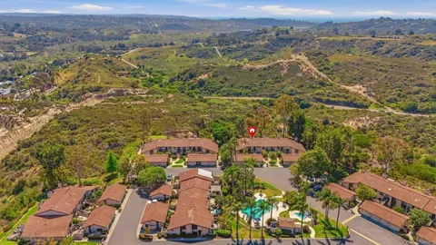 an aerial view of residential houses with outdoor space and trees