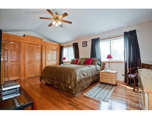 1118 Country Ridge Lane Bolingbrook, IL 60440 - Photo 7 of 16 a spacious bedroom with a large bed a chandelier and windows