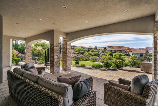 2608 Canyon Ridge Drive St. George, UT 84770 - Photo 76 of 86 Expansive covered patio featuring stone-clad columns, arched openings, recessed lighting, and a paved surface