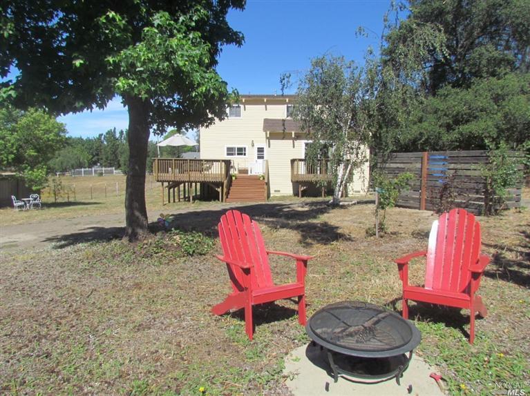 a view of a backyard with table and chairs potted plants and a palm tree