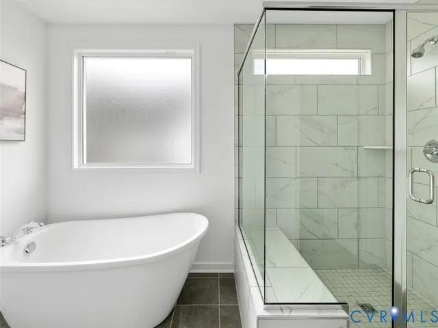 a white bath tub sitting under a bathroom window
